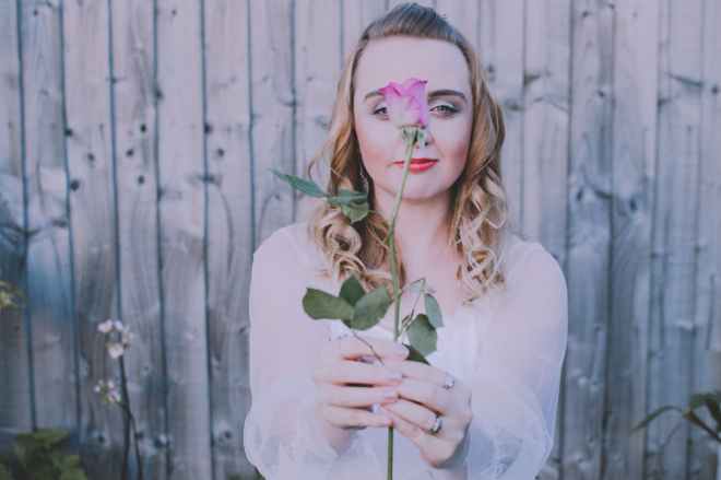 woman holding pink rose
